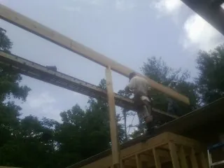 Carpenter setting a ridge beam over a new addition frame — Ice Dam Removal by Roofing Brothers in Bucoda